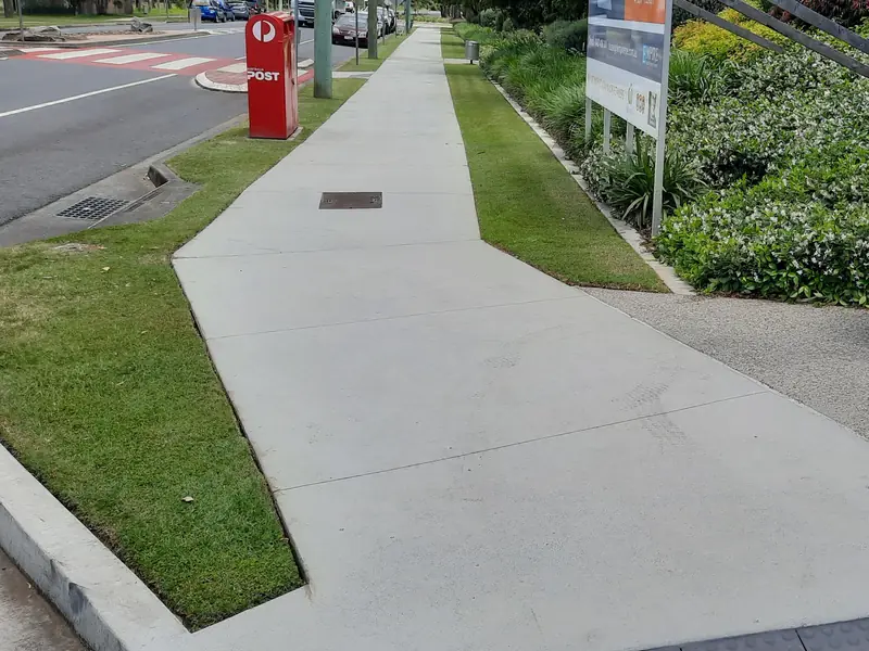 Mown verges and garden beds along the footpath at Jimboomba Central