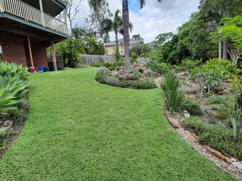 Lush, freshly mown backyard lawn with neatly edged garden beds